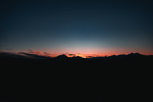 Free A serene view of mountain silhouettes against a twilight sky in Trentino-Südtirol, Italy. Stock Photo