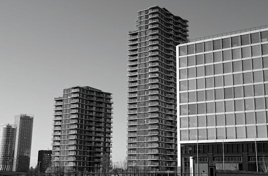 在晴朗的天空下，当代摩天大楼的黑白照片展示了现代建筑设计
