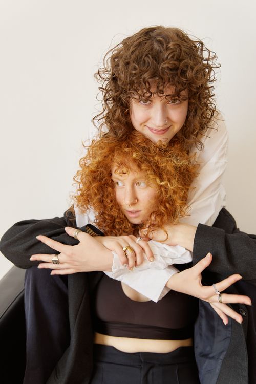 Free Two women with curly hair share a joyful embrace, expressing love and connection. Stock Photo