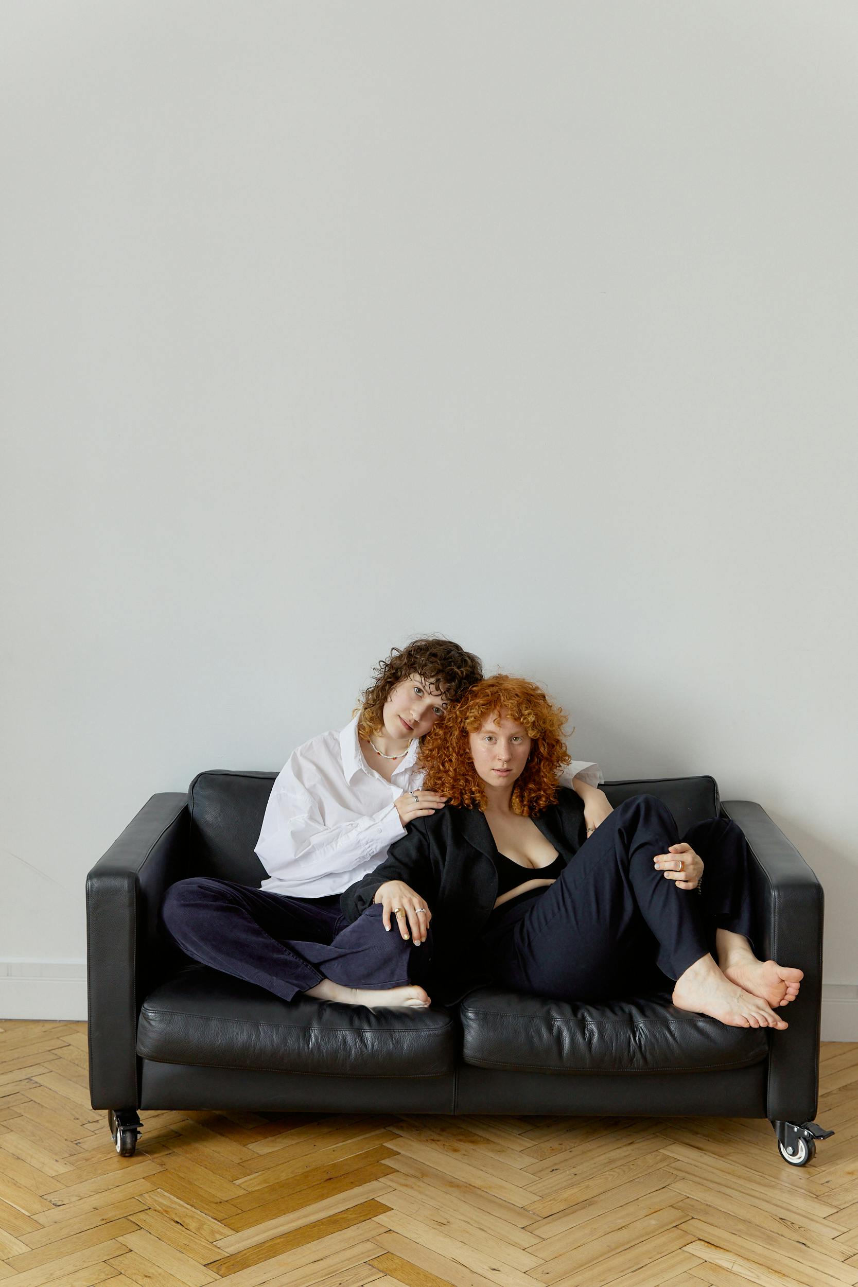 a same sex couple sitting on a leather couch