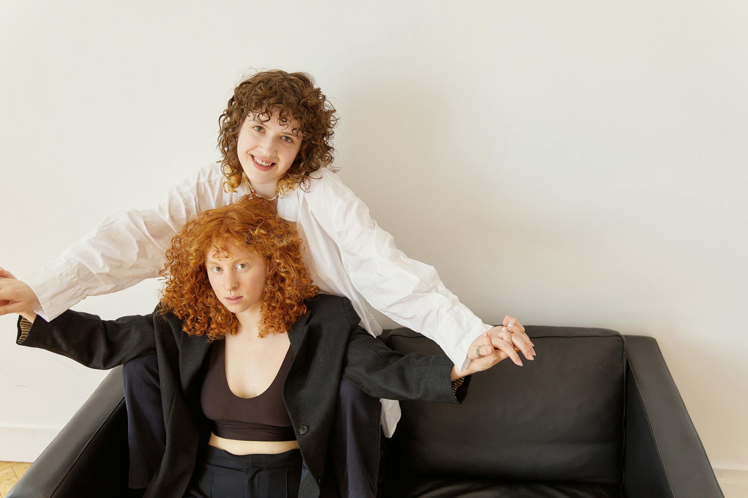 a same sex couple sitting on a leather couch while holding hands