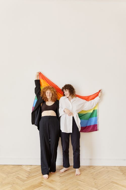 Free A supportive couple holding a rainbow flag symbolizing LGBTQ pride and equality. Stock Photo