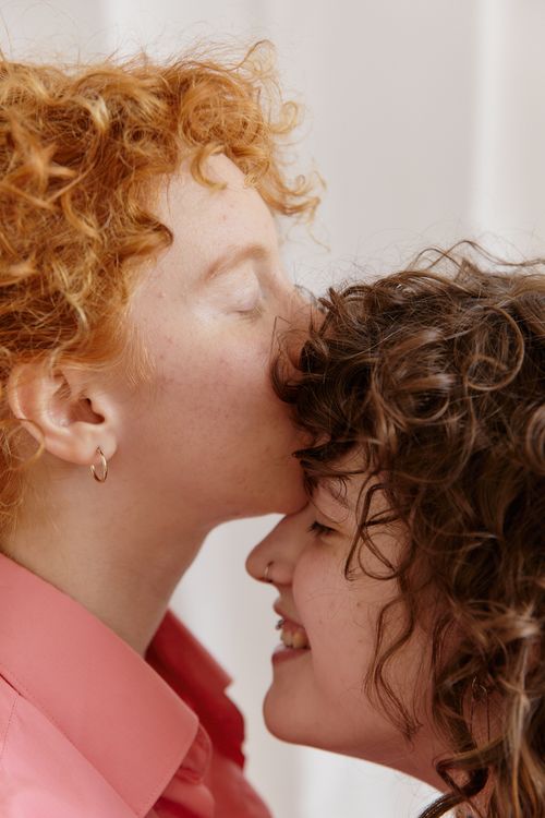 Free Two women sharing a loving and intimate moment together with a tender kiss on the forehead. Stock Photo