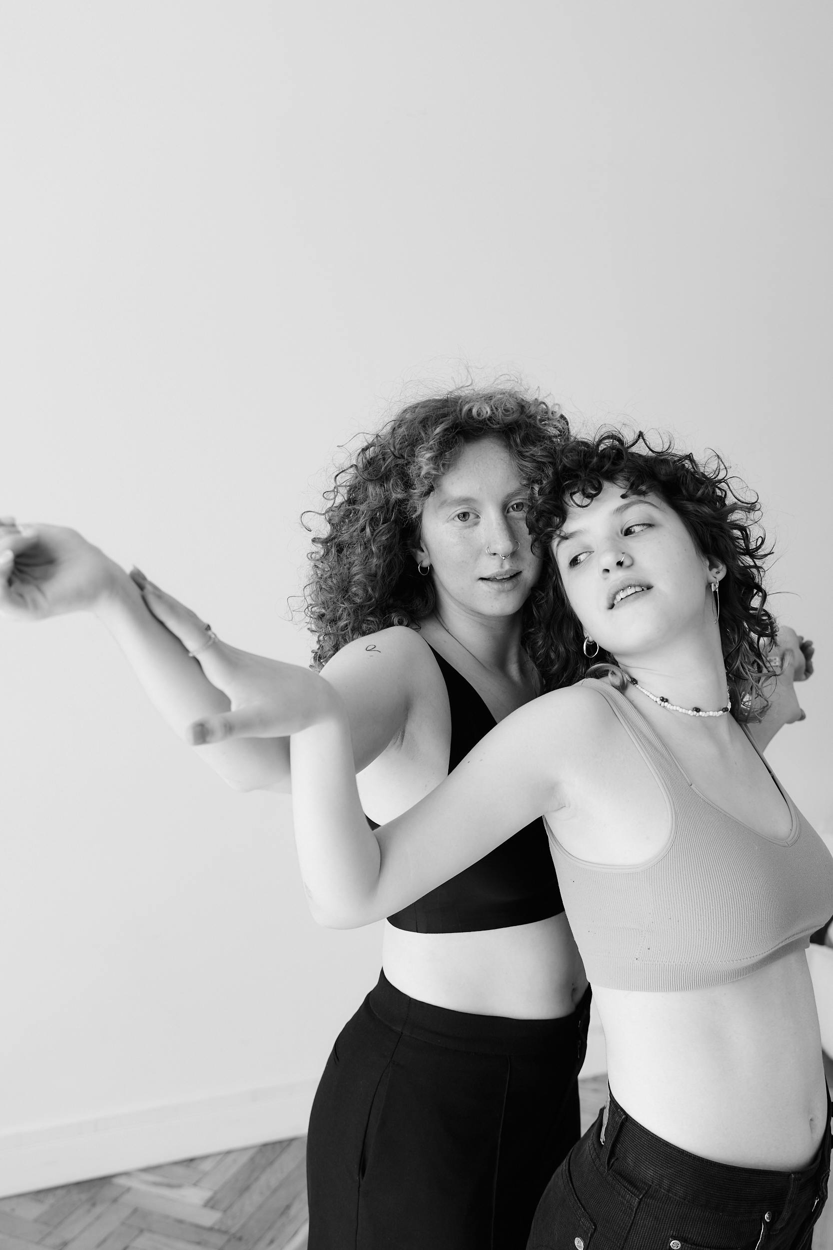 A captivating black and white portrait of two young women dancing expressively.