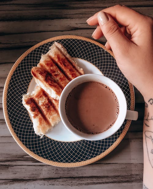 Close-up of a Breakfast with Toasts and Coffee and Womans Hand 