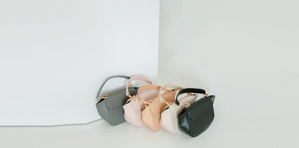 A row of soft-tone bags lined up on a plain shelf — photo by aaron tannando on Pexels