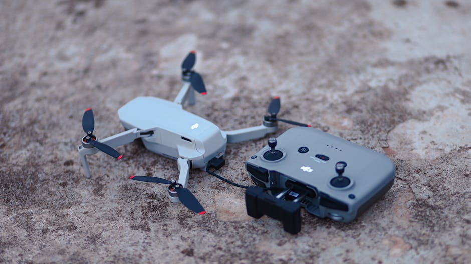 A compact industrial robot arm mounted next to a quadcopter drone on a lab bench, representing autonomous systems software architecture