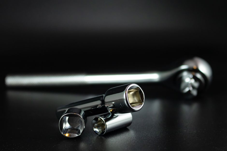 A detailed studio shot of a chrome socket wrench set with a black background, highlighting precision tools.