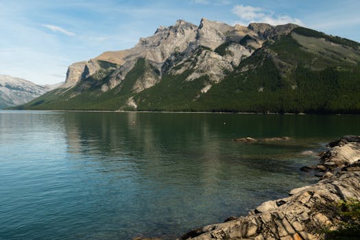 Serene lake and rocky mountains in Banff, Alberta. Perfect for nature photography lovers.