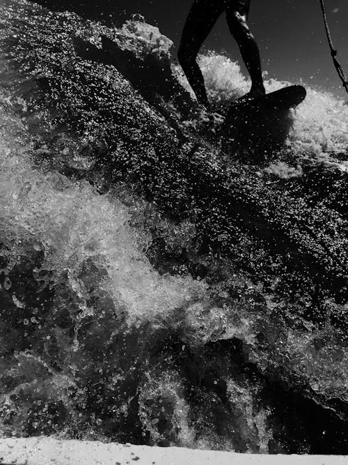 Grayscale Photo of a Person Riding a Wave