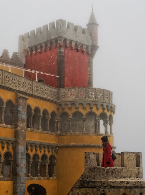 Woman in Red Coat Looking at Pena Palace in Sintra, Portugal