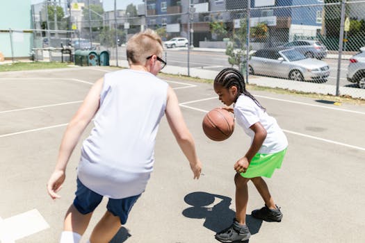 Kids enjoying a game of basketball on a sunny day at a local outdoor court.