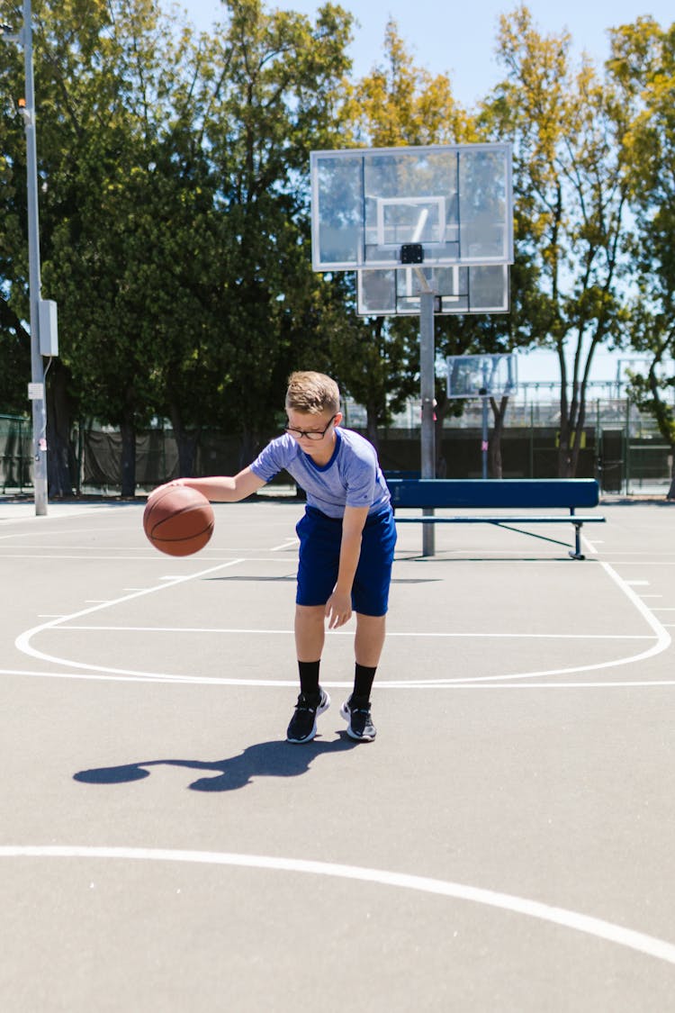 A Boy Playing Basketball Alone