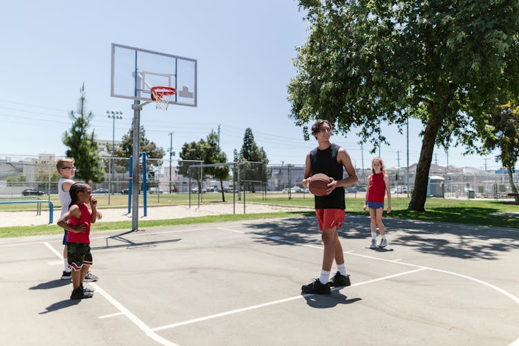 Kids Playing Basketball With Their Coach