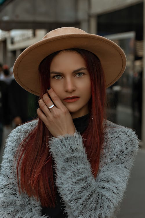 Woman Wearing a Hat with Hand on Cheek