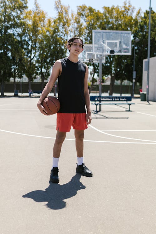 Man in Black Tank Top Holding a Basketball Ball 
