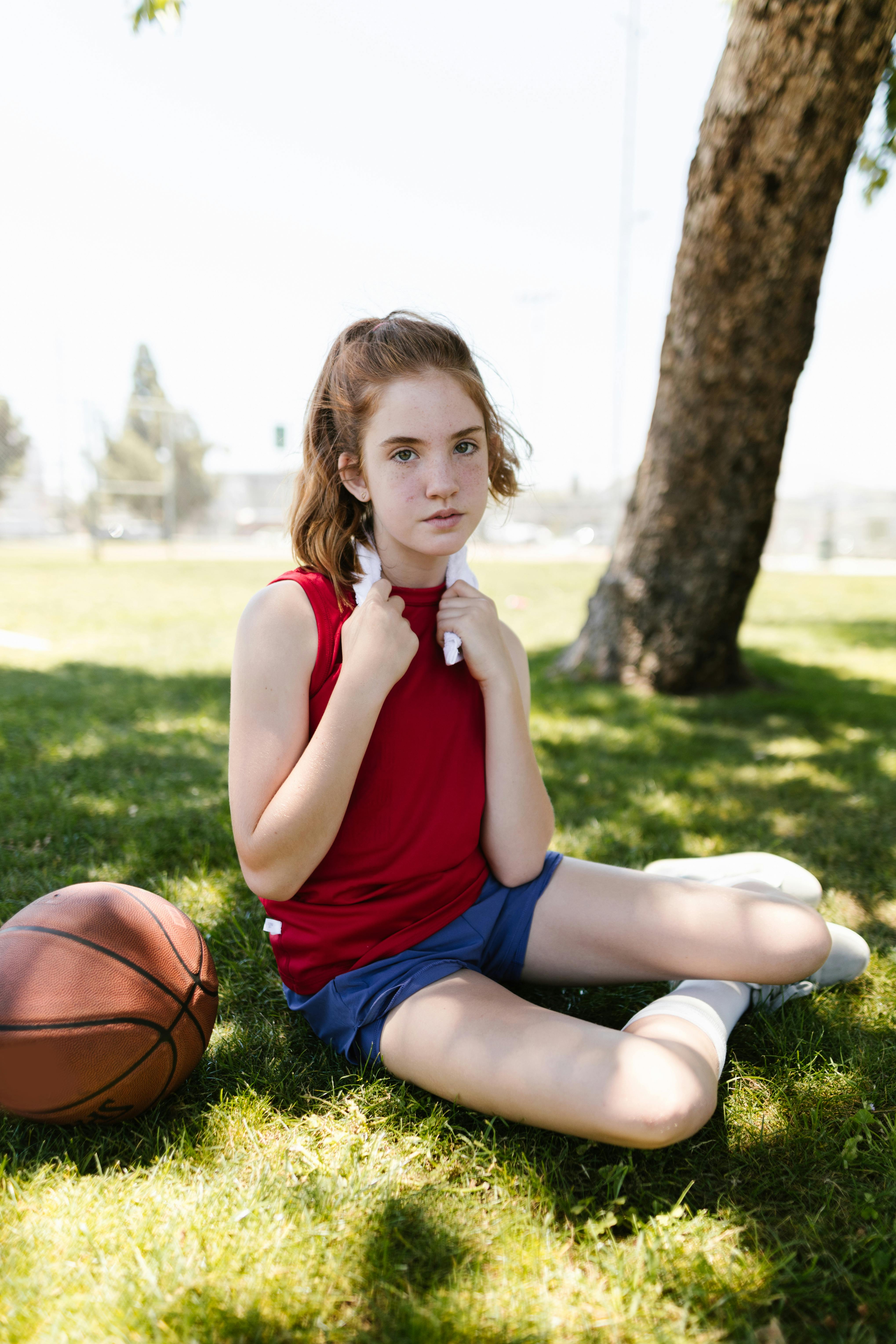 girl sitting beside a ball