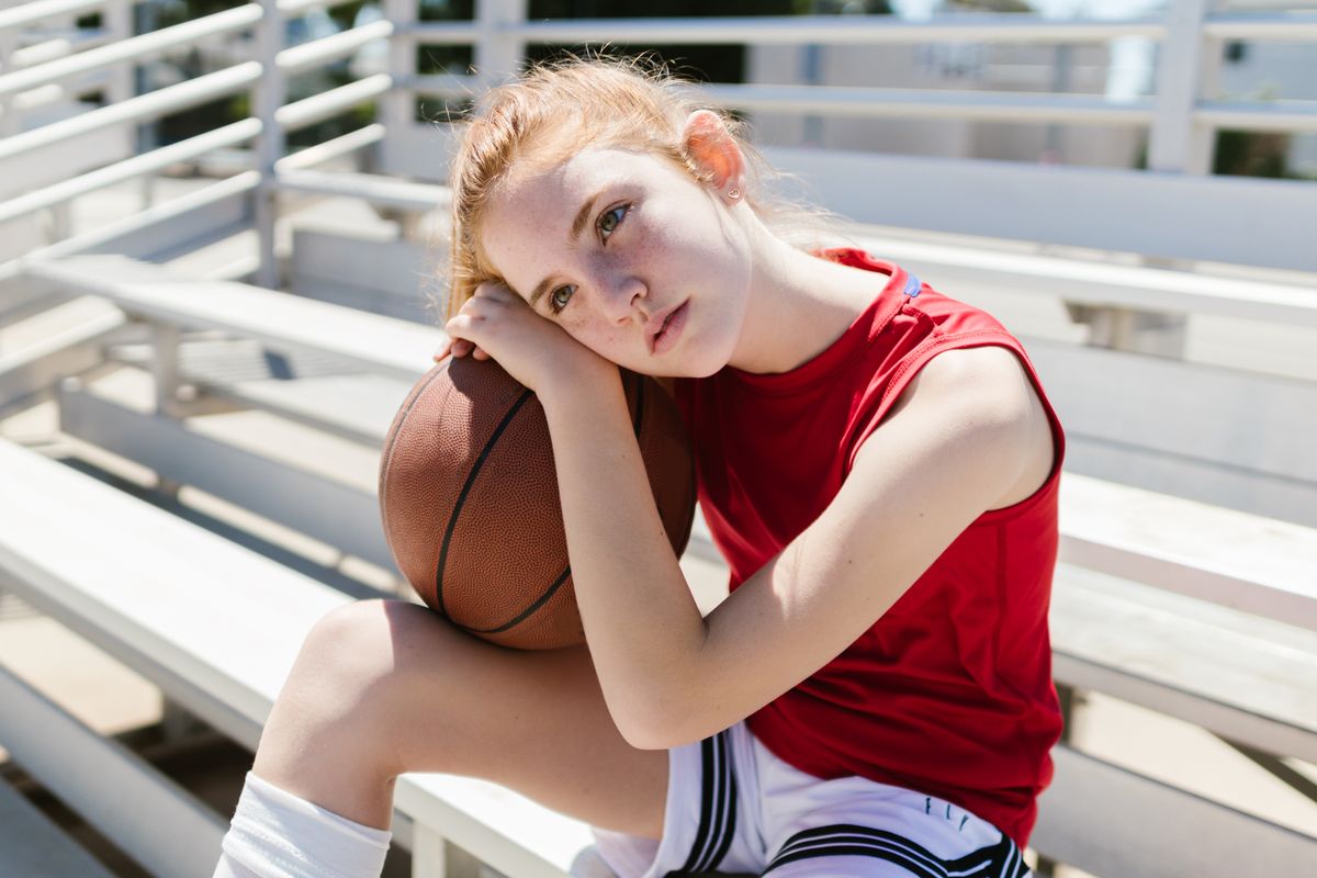 Young athlete sitting on bleachers looking disappointed after a game