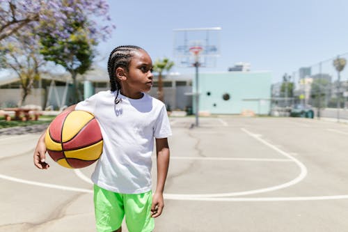 Little Boy with Ball on Basketball Court