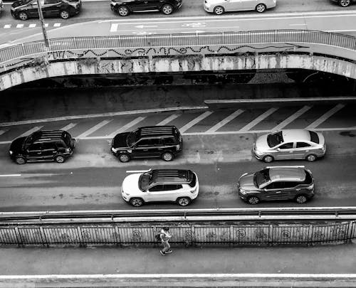 Grayscale Photo of Cars on Road 