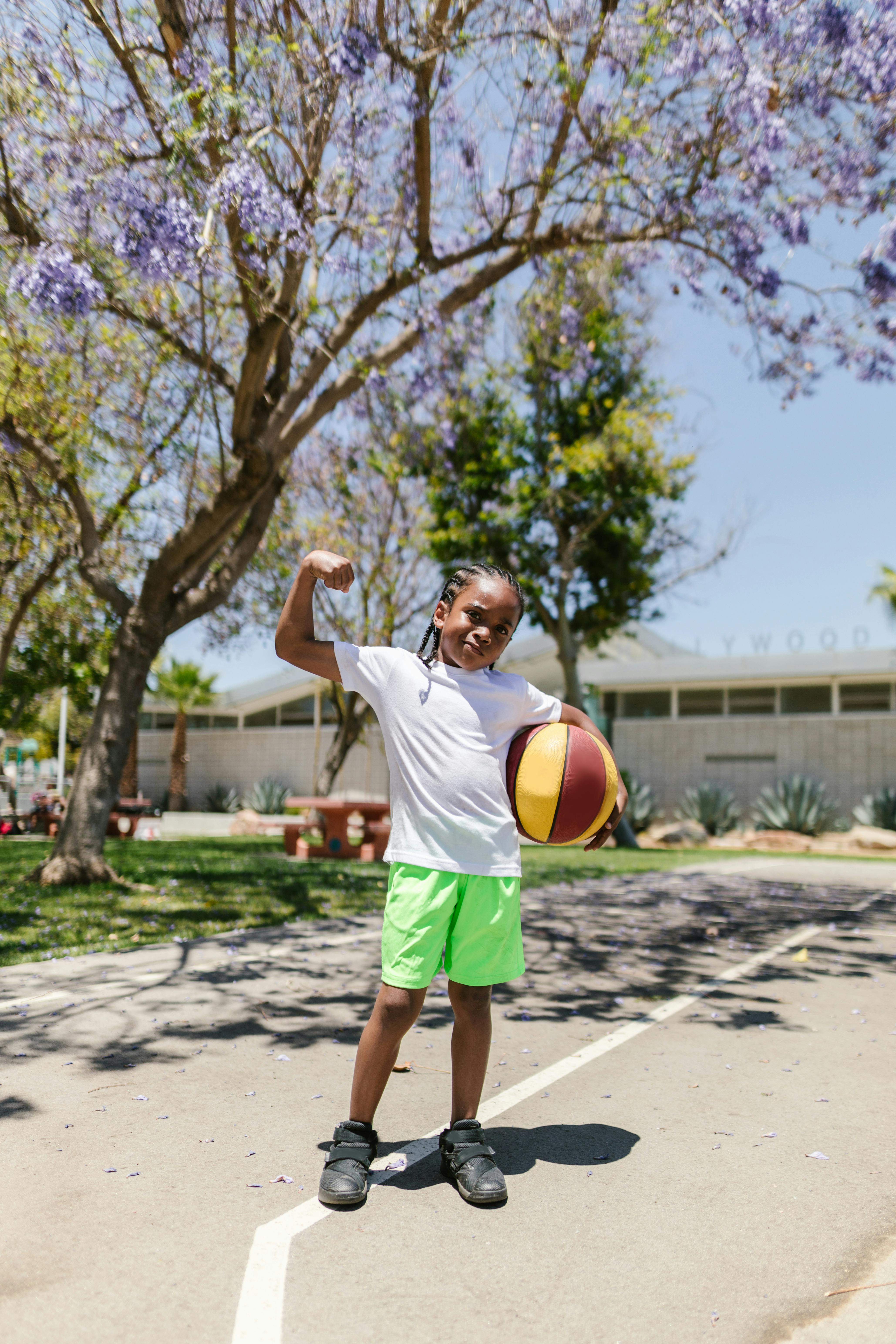 a boy with a basketball flexing his muscles