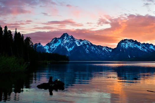 珍妮湖的日出令人叹为观止，白雪皑皑的山脉和宁静的水域映照着充满活力的天空