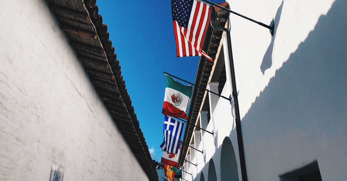 Colorful flags line the historic El Paseo in Santa Barbara, showcasing diverse cultural ties.
