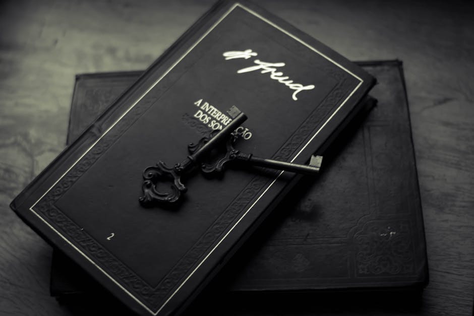 From above of classic metal key placed on black books on wooden table
