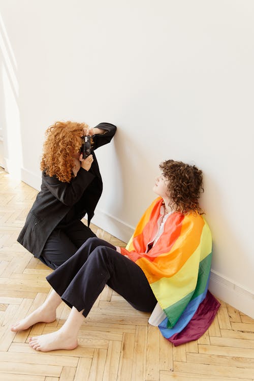 Woman with Rainbow Flag Sitting on Floor at Photo Session