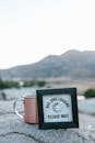 Black Wooden Frame leaning on a Mug