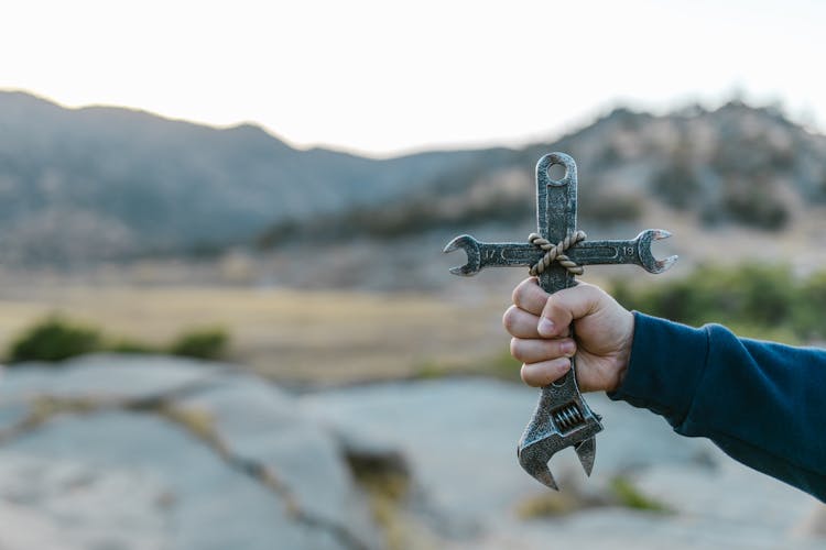 A Hand Holding Metal Wrench 