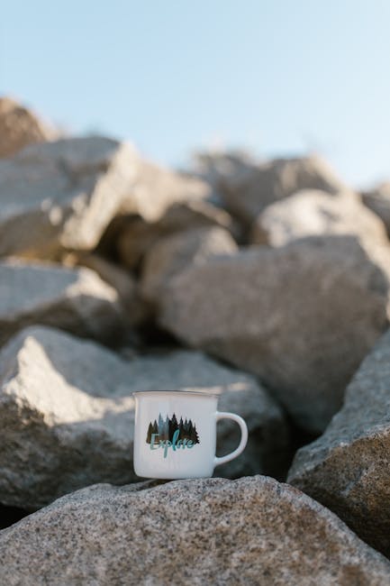 White Ceramic Mug on Gray Rock