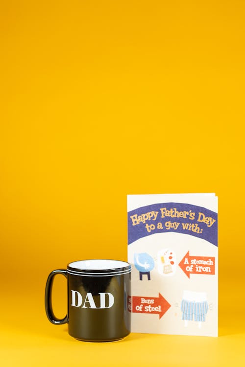 Greeting Card beside Black Ceramic Mug 