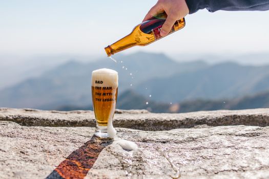 A Person Pouring Beer on Drinking Glass