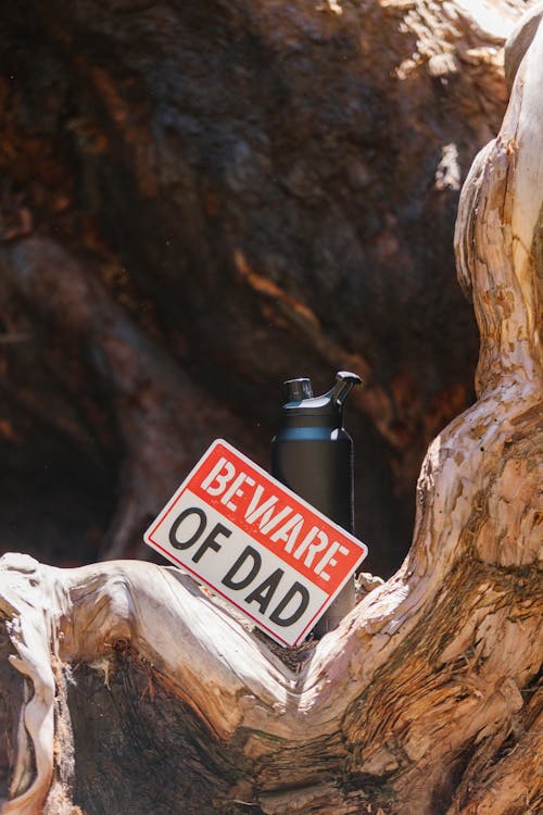 A Drinking Bottle and a Warning Sign on a Tree Trunk