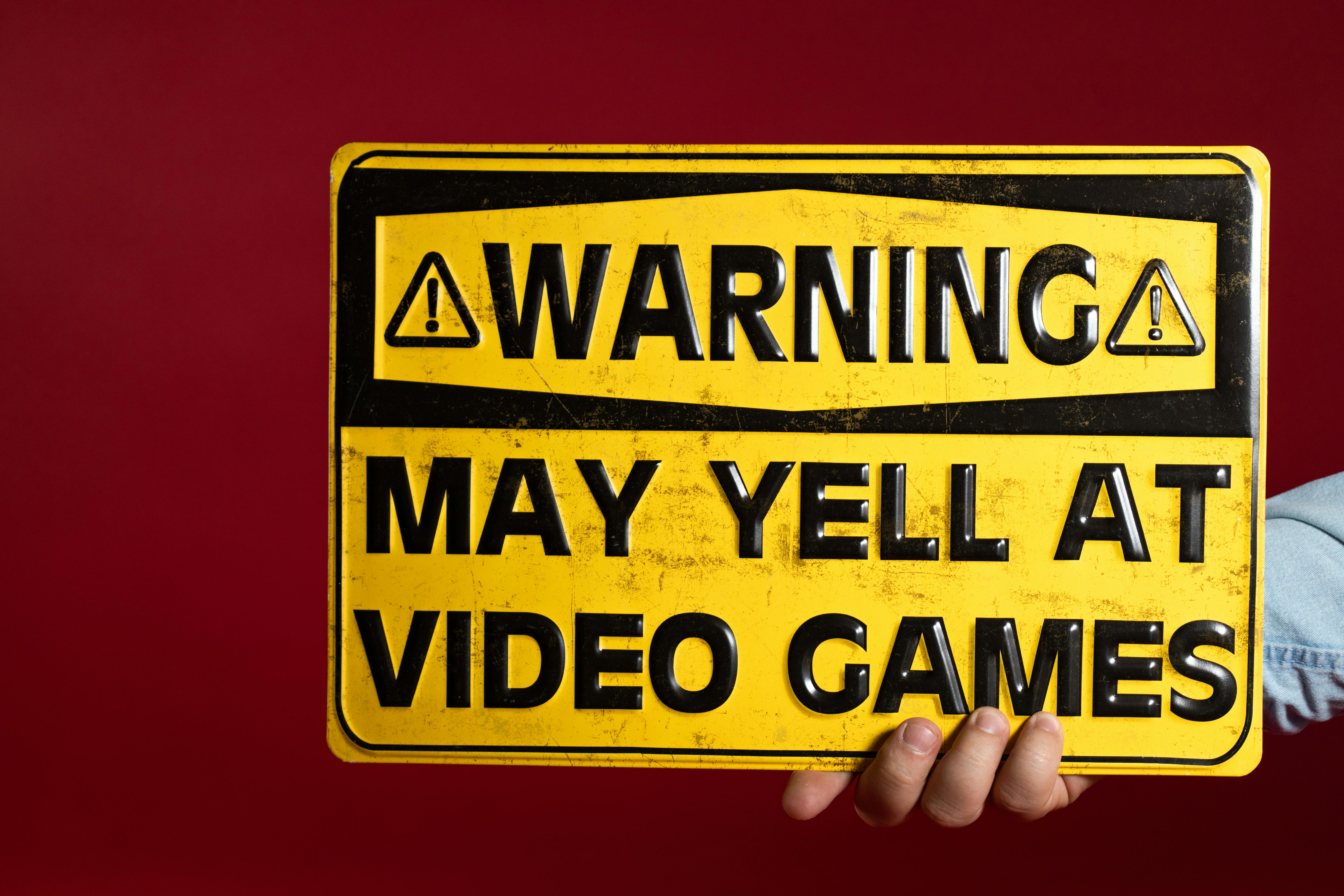 A Person Holding a Yellow Warning Metal Sign Decor