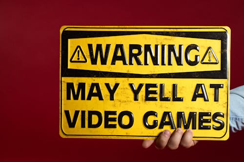 Free A Person Holding a Yellow Warning Metal Sign Decor Stock Photo