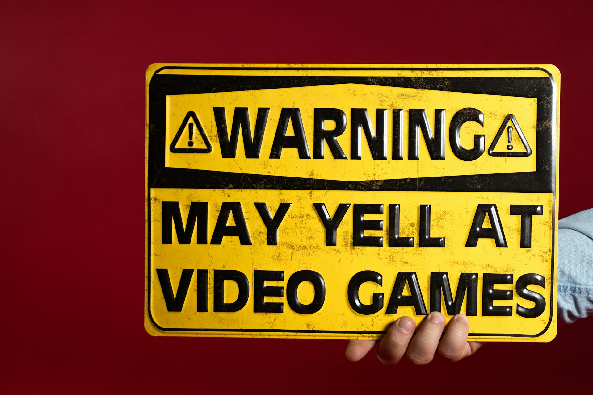 A Person Holding a Yellow Warning Metal Sign Decor