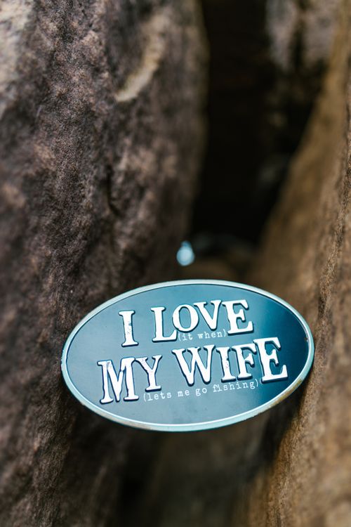 Free A humorous sign reading 'I Love My Wife' placed between rocks, emphasizing fishing humor. Stock Photo
