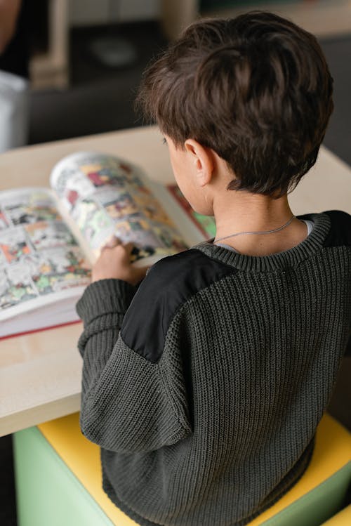 Free Boy in Black Sweater Reading a Comics  Stock Photo