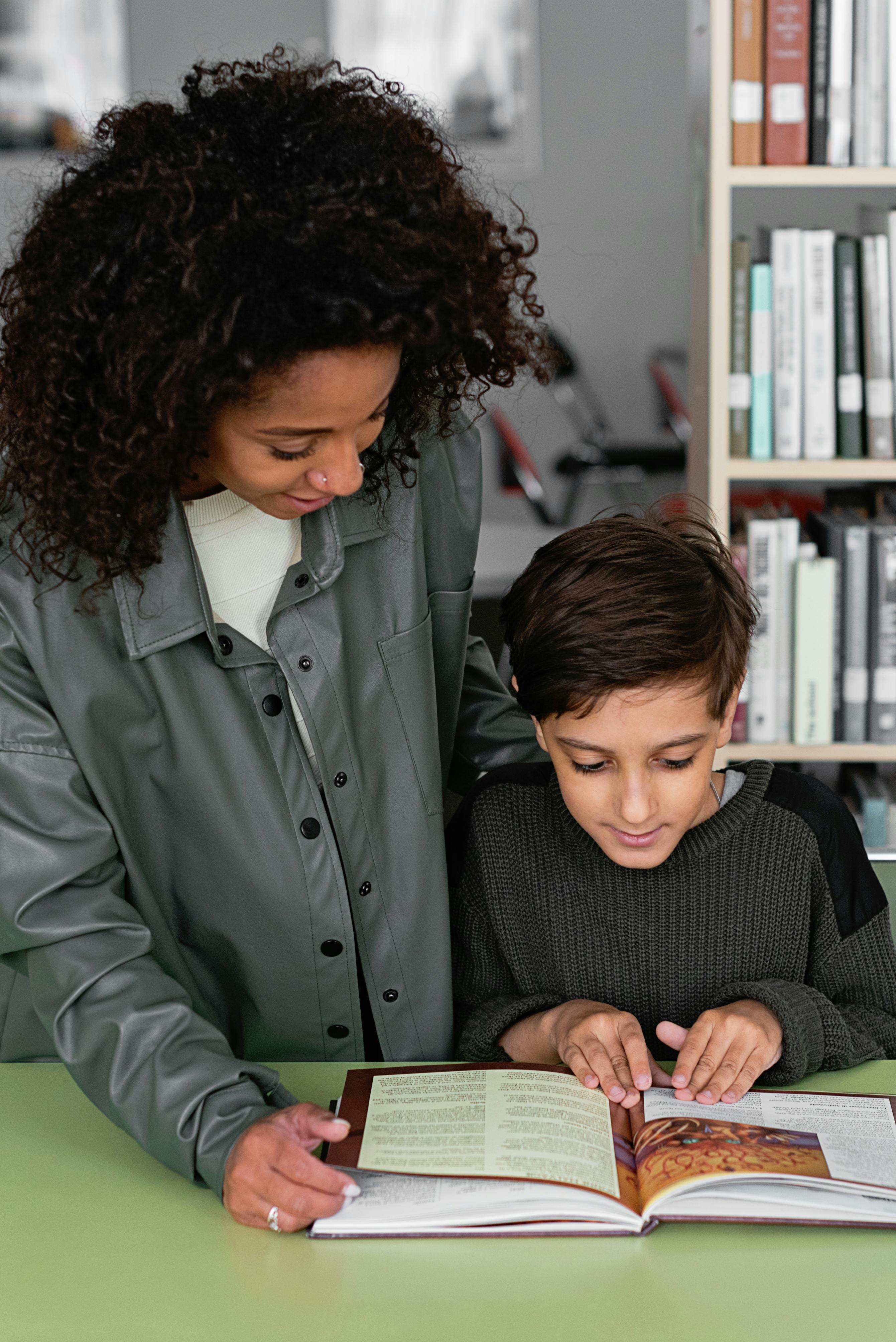 woman in gray jacket beside a boy