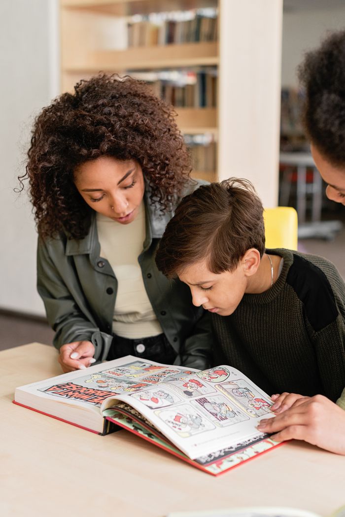Therapist teaching a young boy to read with picture cards