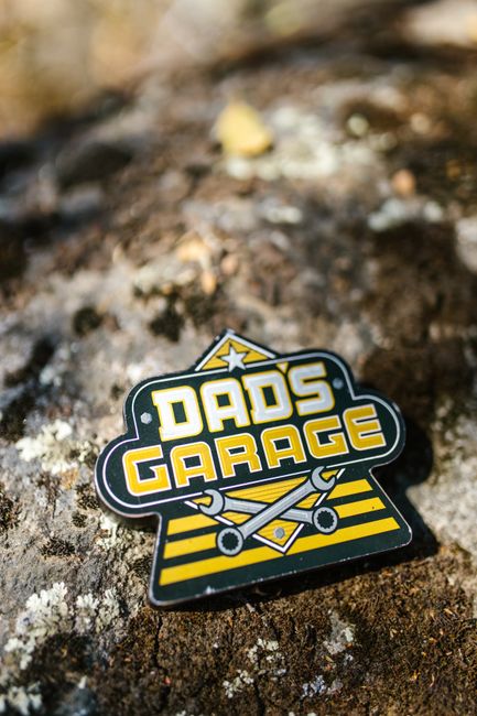 Rustic close-up of a Dads Garage badge on a textured surface, perfect for Father's Day themes.