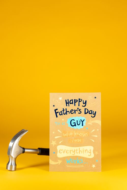 Free A Father's Day card with a hammer on a vibrant yellow background, ideal for celebrations. Stock Photo