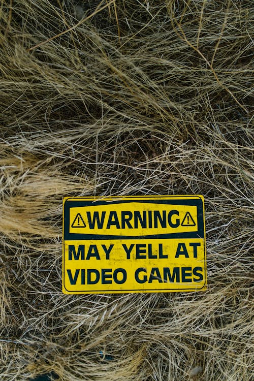 Yellow and Black Warning Signage on Grass