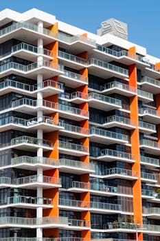 Experience the sleek design of a luxury residential building with vibrant orange accents in Dubai.