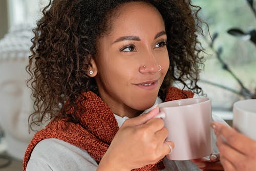 A Woman Smiling while Holding a Mug