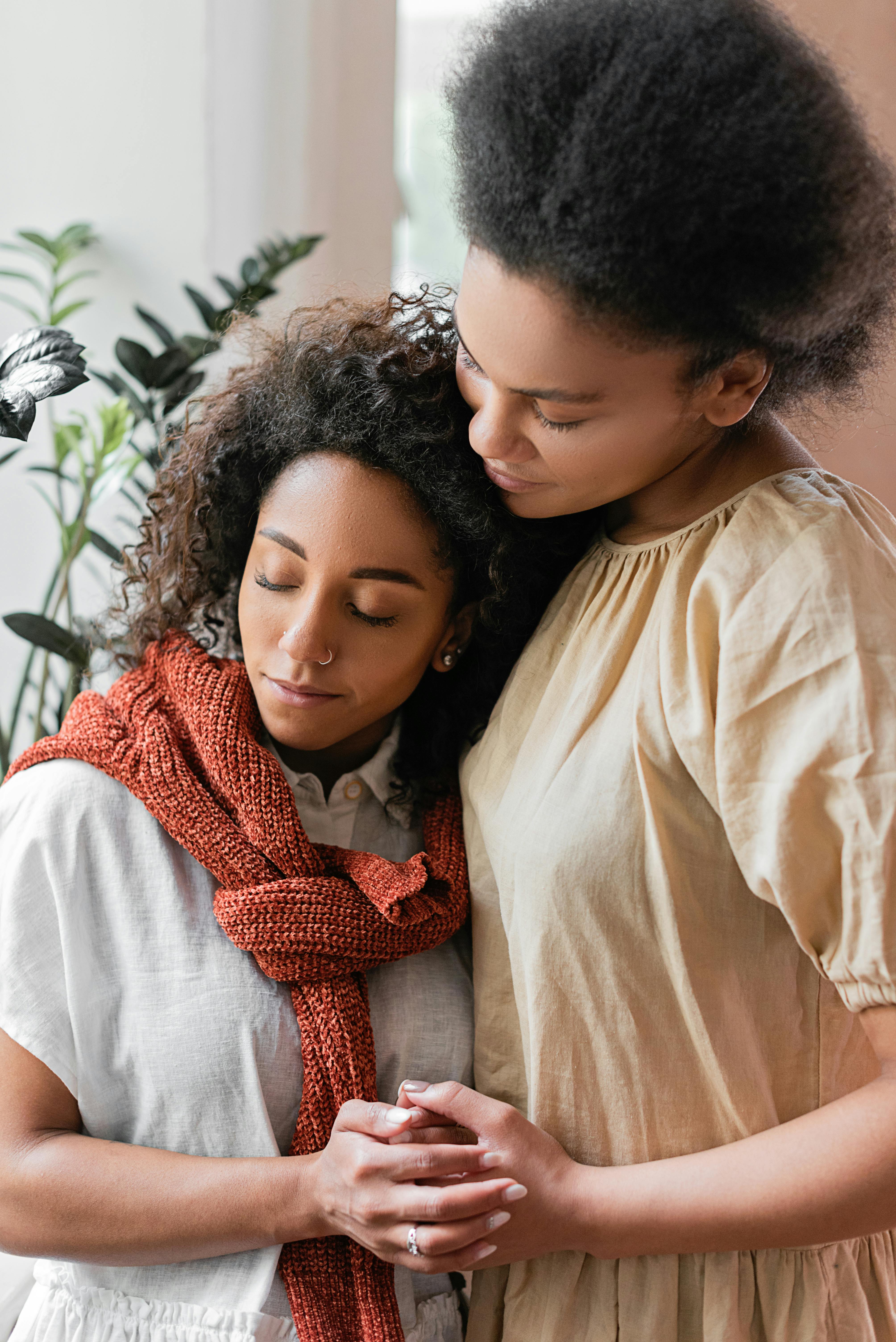 two women hugging and holding hands