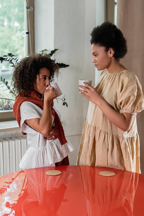 Women Standing Near a Red Table