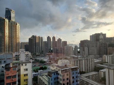 Vibrant cityscape with skyscrapers and residential buildings at sunset.
